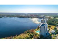 Stunning aerial view of lakeside condo buildings with pool and lush surrounding landscape at 13427 Blue Heron Beach Dr # 1205, Orlando, FL 32821