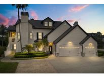 Elegant two-story home featuring a three-car garage, manicured landscaping, and classic architectural details at 13429 Fountainbleau Dr # 13429, Clermont, FL 34711