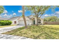 Charming one-story home features a well-maintained lawn, two-car garage and mature shade trees at 2381 Pinebrook Ct, Oviedo, FL 32766