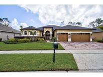 Charming single Gathering home featuring a well-manicured lawn, 3-car garage, and elegant exterior finishes at 2626 Greenwillow Dr, Orlando, FL 32825