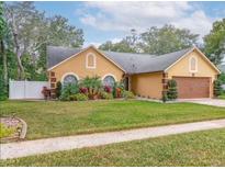 Charming single-story home featuring a well-manicured lawn and lush landscaping at 400 Shelby Ct, Apopka, FL 32712