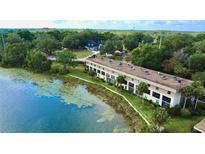 Waterfront condo complex featuring well-maintained landscaping and serene lake views in a scenic setting at 408 E Orlando Ave # 2A, Ocoee, FL 34761