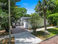 Charming home exterior featuring a brick driveway, lovely landscaping and a palm tree at 506 S Hyer Ave, Orlando, FL 32801