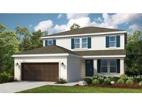Charming two-story home featuring a well-manicured lawn, attached two-car garage, and lovely blue shutters at 549 Moon Shell Cir, New Smyrna Beach, FL 32168