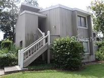 Two-story exterior view featuring a wooden staircase leading to the entrance at 5926 Peregrine Ave # A13, Orlando, FL 32819