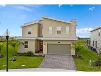 Charming two-story home featuring modern architecture, a stone chimney, and a red front door at 905 Ocean Course Ave, Davenport, FL 33896