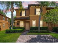 Charming townhome with brick-paved drive, lush landscaping, and inviting curb appeal at 130 Palermo St, Davenport, FL 33897