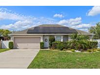 Charming single Gathering home featuring solar panels, well-maintained landscaping, and a two-car garage at 1942 N Portillo Dr, Deltona, FL 32738