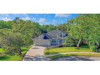 Charming single-Gathering home featuring a paver driveway, attached garage, and lush landscaping at 203 Red Bud Ct, Lake Mary, FL 32746