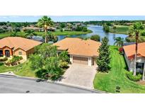 Beautiful single-story home with a manicured lawn, brick driveway, and a scenic waterfront view at 313 Sorrento Rd, Poinciana, FL 34759