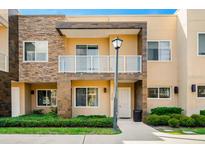Charming two-story townhome with a decorative stone facade, balcony and well-maintained landscaping at 3228 Brasilia Ave, Kissimmee, FL 34747