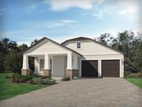 Charming single-Gathering home featuring a covered front porch, dark garage doors, and beautiful landscaping at 5290 Citrus Leaf Blvd, Winter Garden, FL 34787