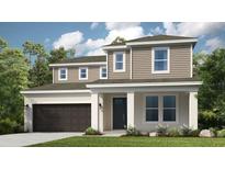 Charming two-story home with a well-manicured lawn, gray siding, and attached two car garage at 548 Moon Shell Cir, New Smyrna Beach, FL 32168