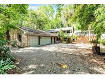 Sprawling single story brick home featuring an attached three car garage and long driveway at 102 Wild Plum Ln, Longwood, FL 32779