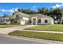 Charming single-story home featuring a well-manicured lawn and a brick driveway at 2425 Rambling Oaks Way, Kissimmee, FL 34746