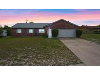 Charming brick home featuring a well-maintained lawn and attached two-car garage at 549 Mcneal Dr, Deltona, FL 32725