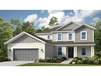 Charming two-story home showcasing a covered entry, neutral color palette, and a well-maintained lawn at 853 Junonia Blvd, New Smyrna Beach, FL 32168