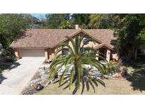 Charming home featuring desert landscaping and a well-manicured yard with a fresh brown roof and mature palm tree at 913 Red Fox Rd, Altamonte Springs, FL 32714