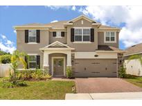 Charming two-story home featuring stone accents, a two-car garage, and a brick-paved driveway at 1118 Franklin Tree Ln, Sanford, FL 32771