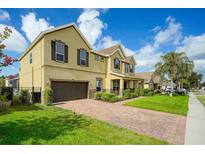 Charming two-story home with a brick driveway, manicured lawn and a two-car garage at 1802 Candlenut Cir, Apopka, FL 32712