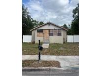 Small one story home with boarded up windows and door and white fence surrounding the lot at 1905 S Westmoreland Dr, Orlando, FL 32805