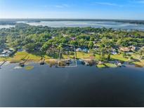 Stunning aerial view of lakefront home with lush landscaping and private dock access at 2926 Marquesas Ct, Windermere, FL 34786