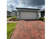 Charming single-story home with a brick driveway and well-maintained landscaping at 6028 Bimini Ave, Haines City, FL 33844