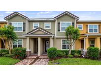 Charming townhome featuring a well-maintained lawn, brick walkway and neutral color scheme at 7660 Ripplepointe Way, Windermere, FL 34786