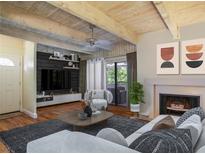 Inviting living room boasts beamed ceilings, fireplace, and sleek, modern furniture for relaxation at 102 Fairway Dr # 102, Longwood, FL 32779