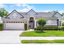 Charming single-story home with a gray exterior, manicured lawn, and well-kept landscaping at 131 Wimbledon Cir, Lake Mary, FL 32746