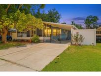 Charming home exterior featuring a gated drive, lush lawn, and mature trees at 133 Moss Dr, Debary, FL 32713