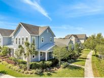 Charming blue two-story home featuring a well-manicured front yard with lush landscaping at 13618 Briand Ave, Orlando, FL 32827