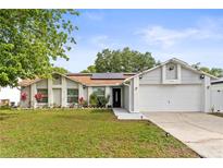 Charming single-story home with well-manicured lawn, flower beds, and a two-car garage at 211 Dalton Dr, Kissimmee, FL 34758