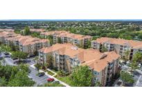 A beautiful aerial view of multiple apartment buildings featuring large parking lots and lush trees at 2781 Almaton Loop # 404, Kissimmee, FL 34747