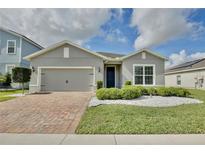 Charming single-story home featuring a brick driveway, two-car garage, and well-manicured landscaping at 299 Whirlaway Dr, Davenport, FL 33837