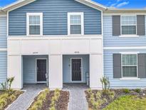 Charming townhome exterior featuring a two-tone facade, well-manicured landscaping, and inviting front entrances at 4098 Lana Ave, Davenport, FL 33897