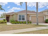 Charming single-story home featuring a well-manicured lawn and a two car garage at 427 Highland Meadows St, Davenport, FL 33837