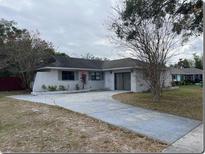 Charming one-story home featuring a spacious driveway and mature landscaping at 4736 Southold St, Orlando, FL 32808