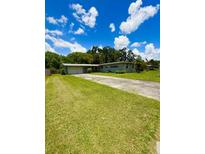Ranch-style home with a spacious front yard and long driveway leading to a two-car garage at 532 Madison Ave, Orlando, FL 32805