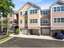 Beautiful three-story townhome featuring an attached two car garage and neutral paint colors at 6685 Queens Borough Ave # 202, Orlando, FL 32835