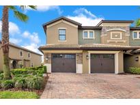 Charming multi-story home featuring a two-car garage and well-manicured landscaping with an inviting brick driveway at 9044 Azalea Sands Ln # 4011, Davenport, FL 33896