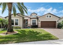 Charming home boasts a lush green lawn, palm tree and manicured landscaping at 5004 Hartwell Ct, St Cloud, FL 34771