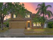 Charming two-story home with a well-maintained lawn, mature trees, and inviting curb appeal at 108 Portstewart Dr, Orlando, FL 32828