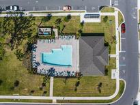 Aerial view of community pool with lounge chairs, cabana, and lush landscaping at 4012 Meandering Bay Dr, Apopka, FL 32712