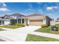 Inviting single-story home with a spacious driveway, lush lawn, and well-maintained landscaping at 4012 Meandering Bay Dr, Apopka, FL 32712