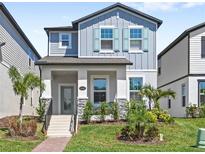 Charming two-story home with gray siding, teal shutters, and beautifully landscaped front yard at 12067 Eastmoor Dr, Winter Garden, FL 34787