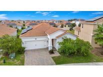 A charming home features a clay tile roof and solar panels at 1415 Oak Marsh St, Davenport, FL 33837