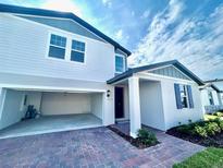 Charming two-story home featuring brick paver driveway, attached two-car garage, and welcoming entrance at 1513 Congaree St # 1513, Davenport, FL 33837