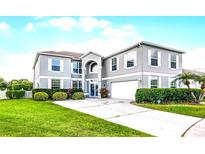 Beautiful two-story home with a well-manicured lawn and driveway leading up to the attached two-car garage at 219 Strathmore Cir, Kissimmee, FL 34744