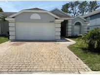 Charming single-story home with a well-manicured lawn and a brick driveway at 2218 Newt St, Orlando, FL 32837